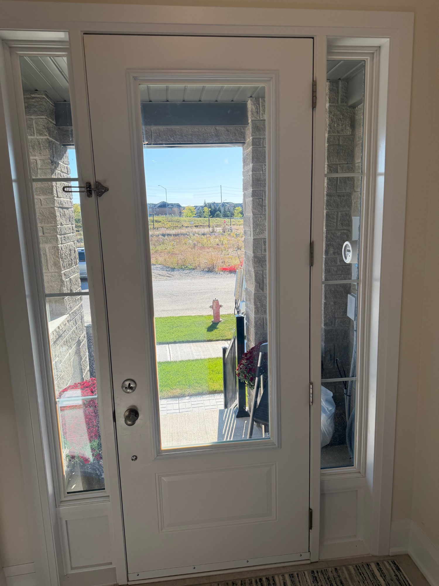 Front door glass and both sidelites seen from inside a new GTA home, security film installed with a caulked perimeter
